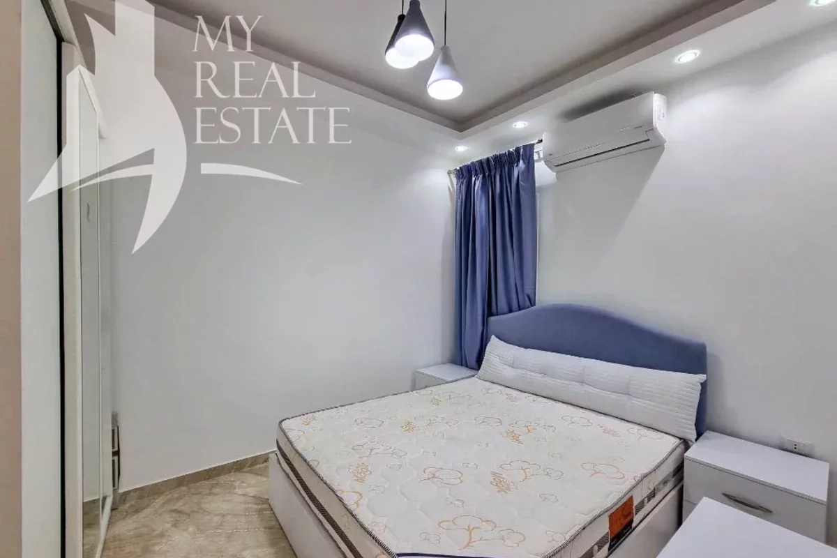 Кровать с изголовьем в небольшой спальне квартиры в Хургаде