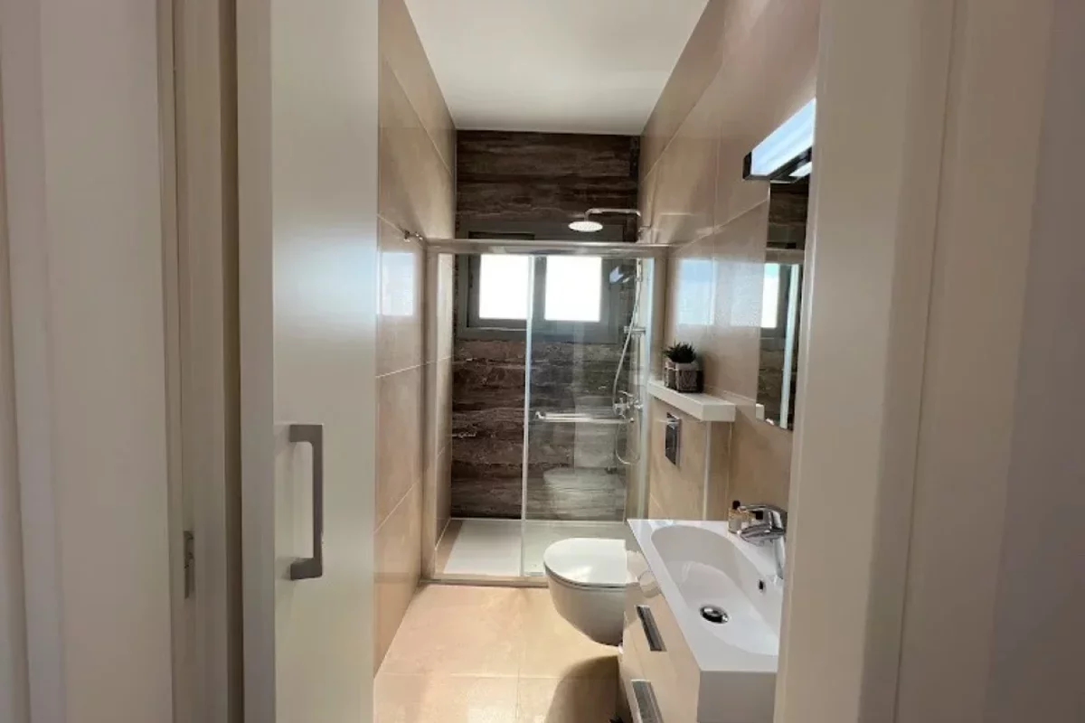 Ванная комната с бежевой плиткой в квартире с видом на море на Кипре