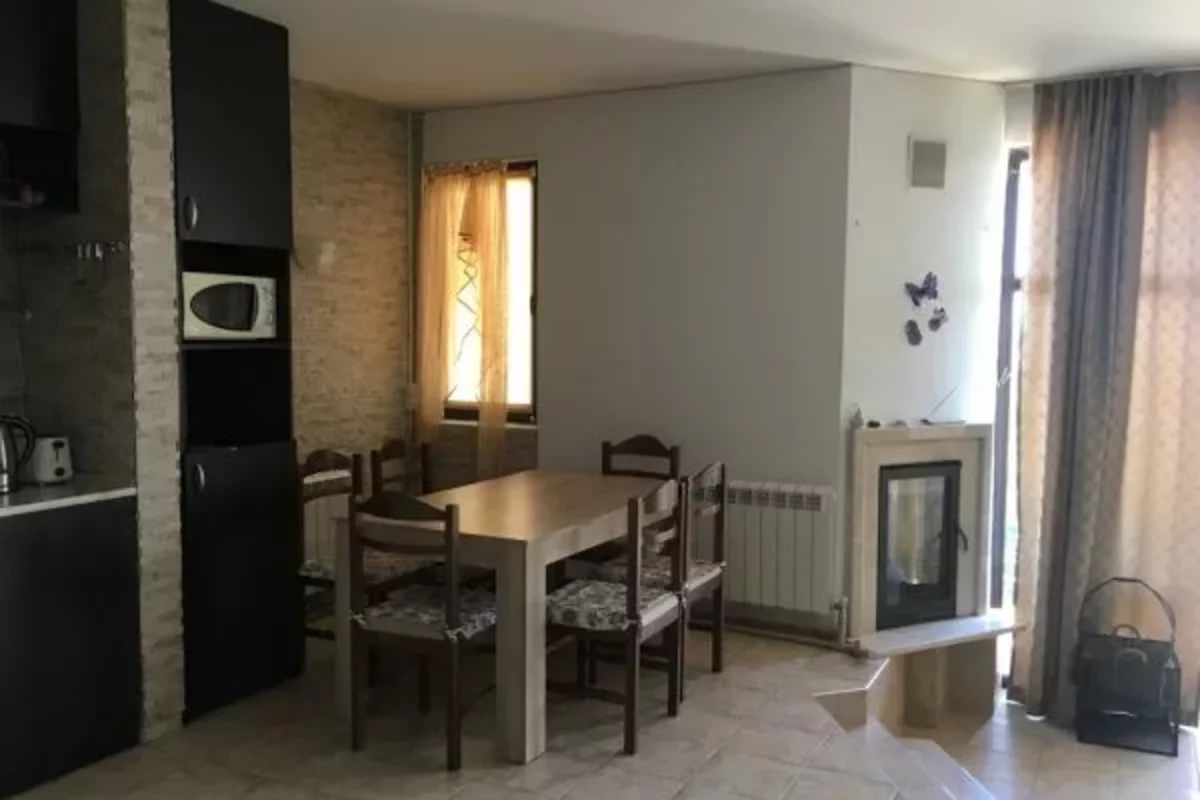 Стол, столья и камин на кухне дома в Болгарии