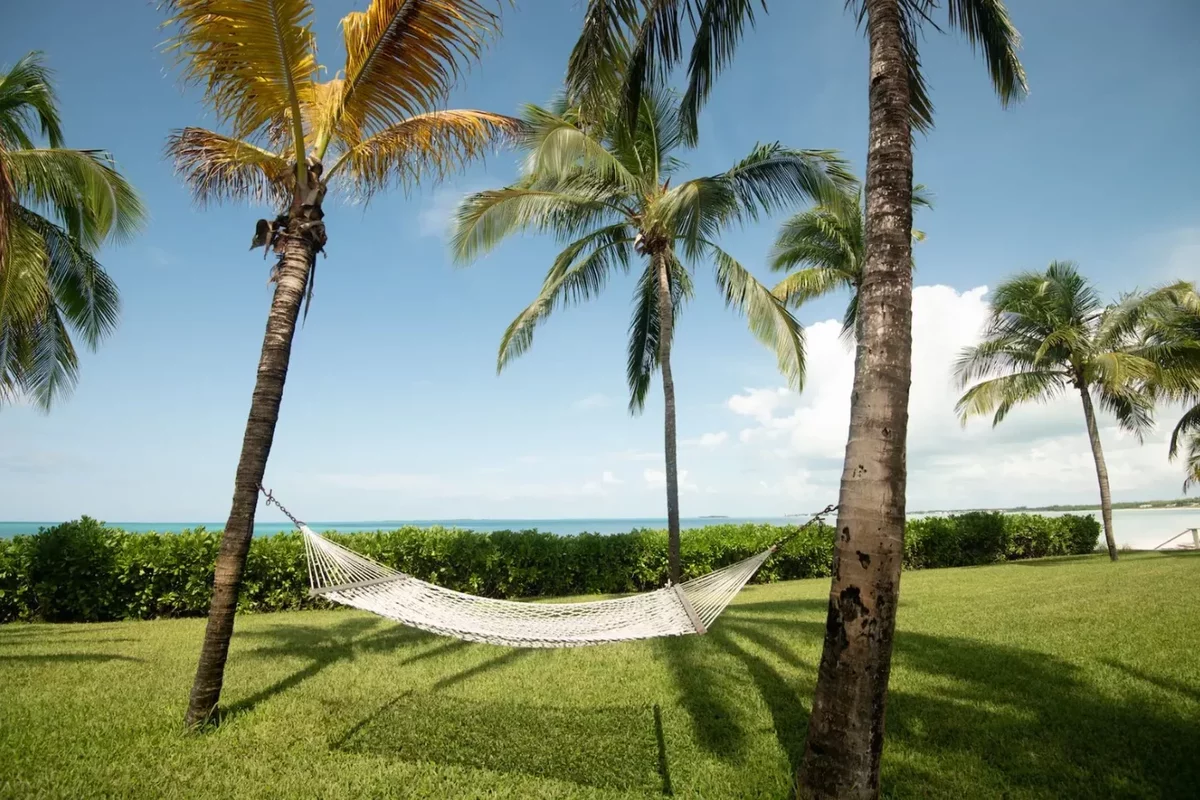 A hammock between palm trees on the grounds of a villa in the Bahamas