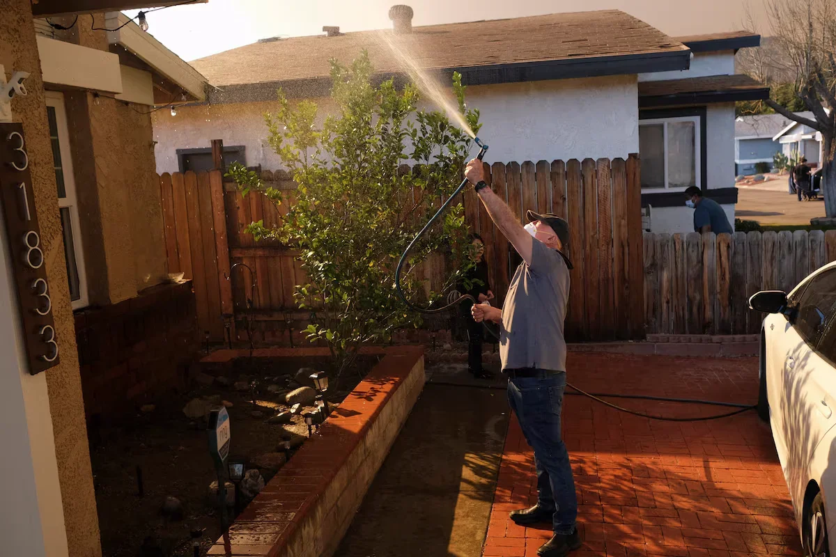 Thomas Carbajal is dousing his house with water