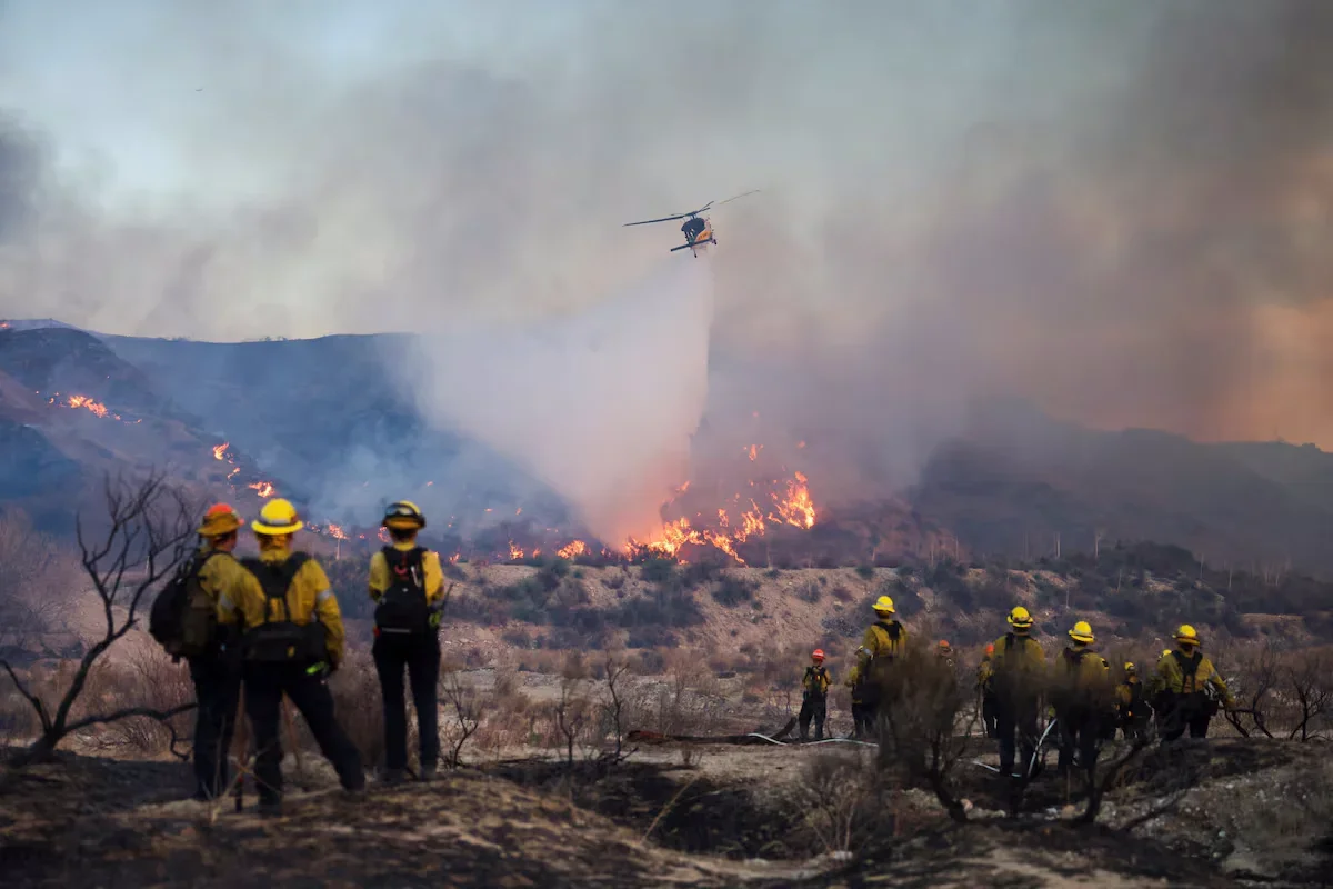 A helicopter dumps water during the fire