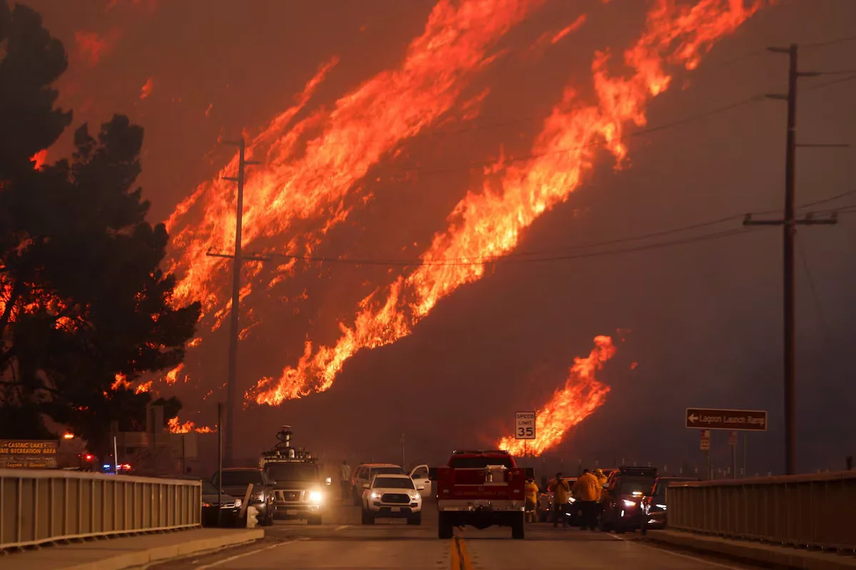 Flames rise behind the vehicles during the fire