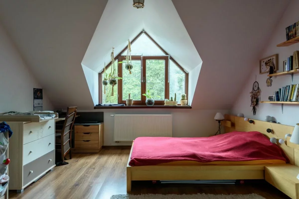 An unusually shaped window in the bedroom on the second floor of a townhouse in Lomianki, Poland