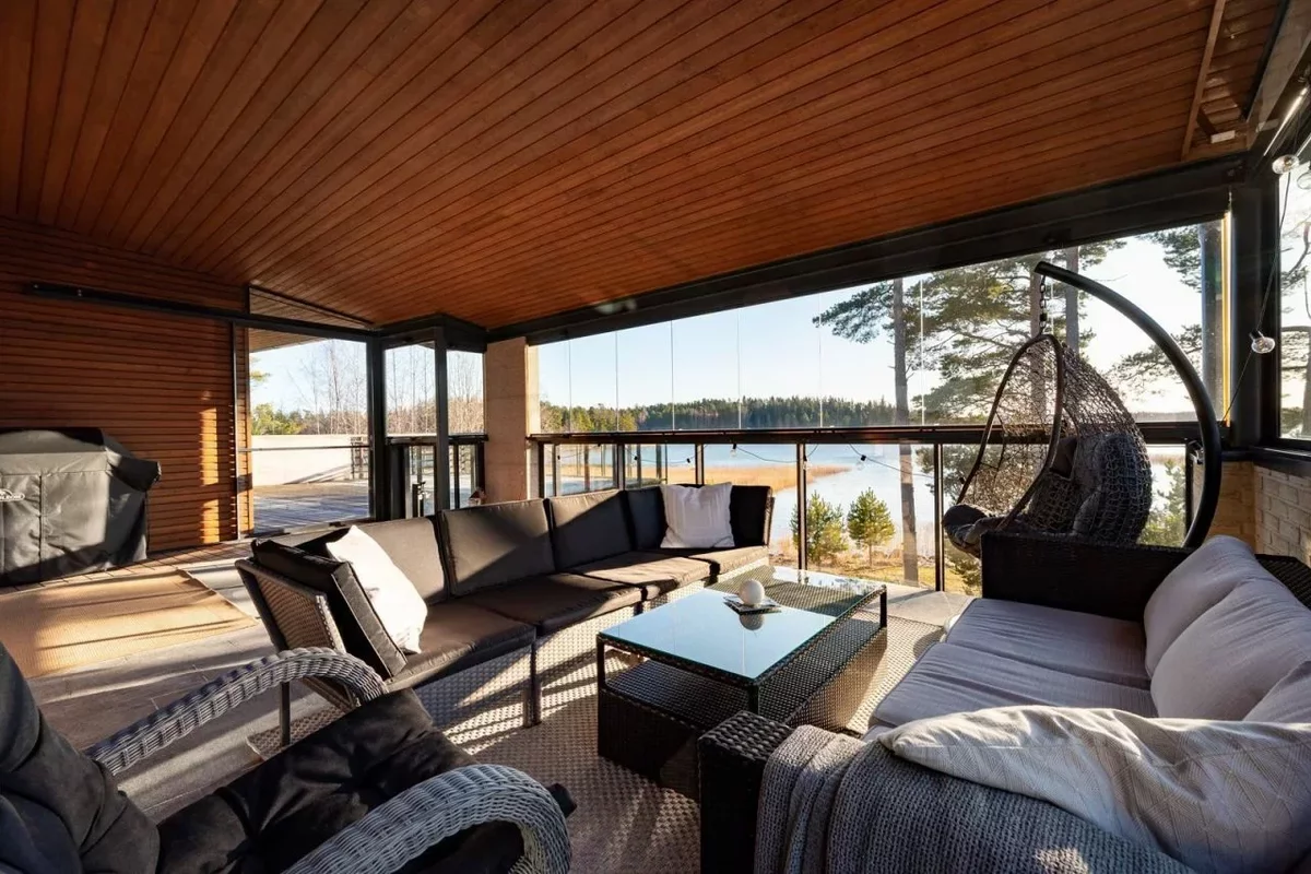 Крытая терраса с видом на озеро в доме в Финляндии