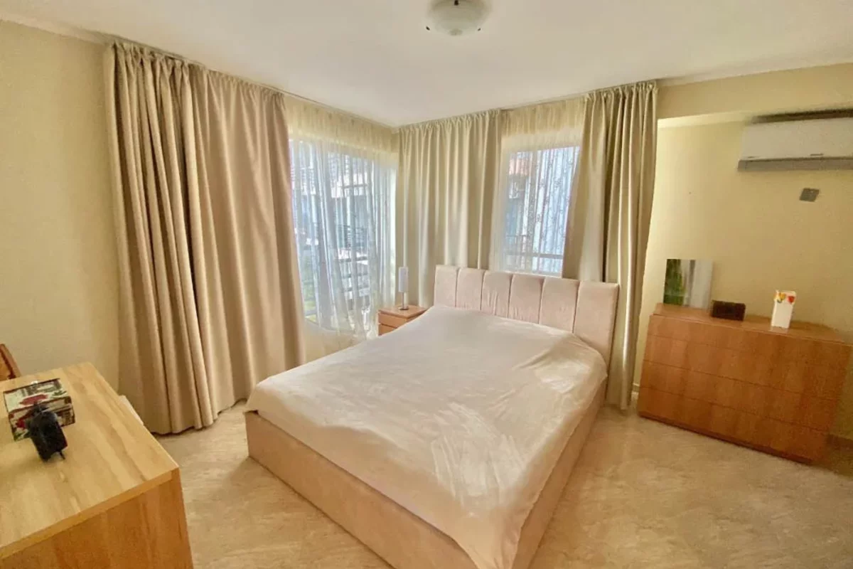 Шторы и кровать в спальне в квартире в Болгарии