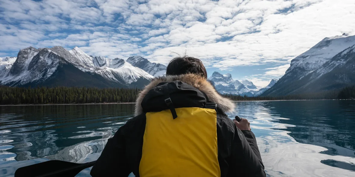 A traveler canoes through the Canadian Rockies on Maligne Lake in Jasper National Park