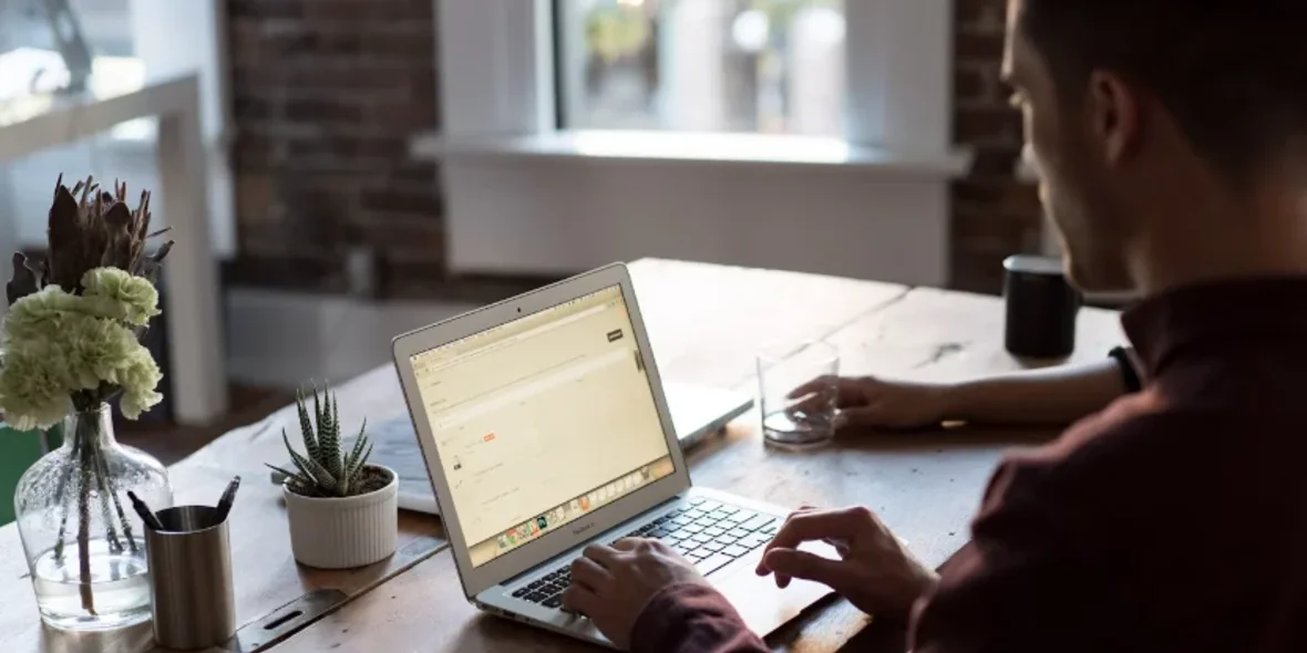 a man works on a laptop in a coffee shop
