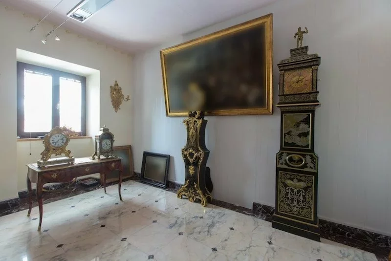 A large painting, a floor clock and an old desk in a castle in Slovenia