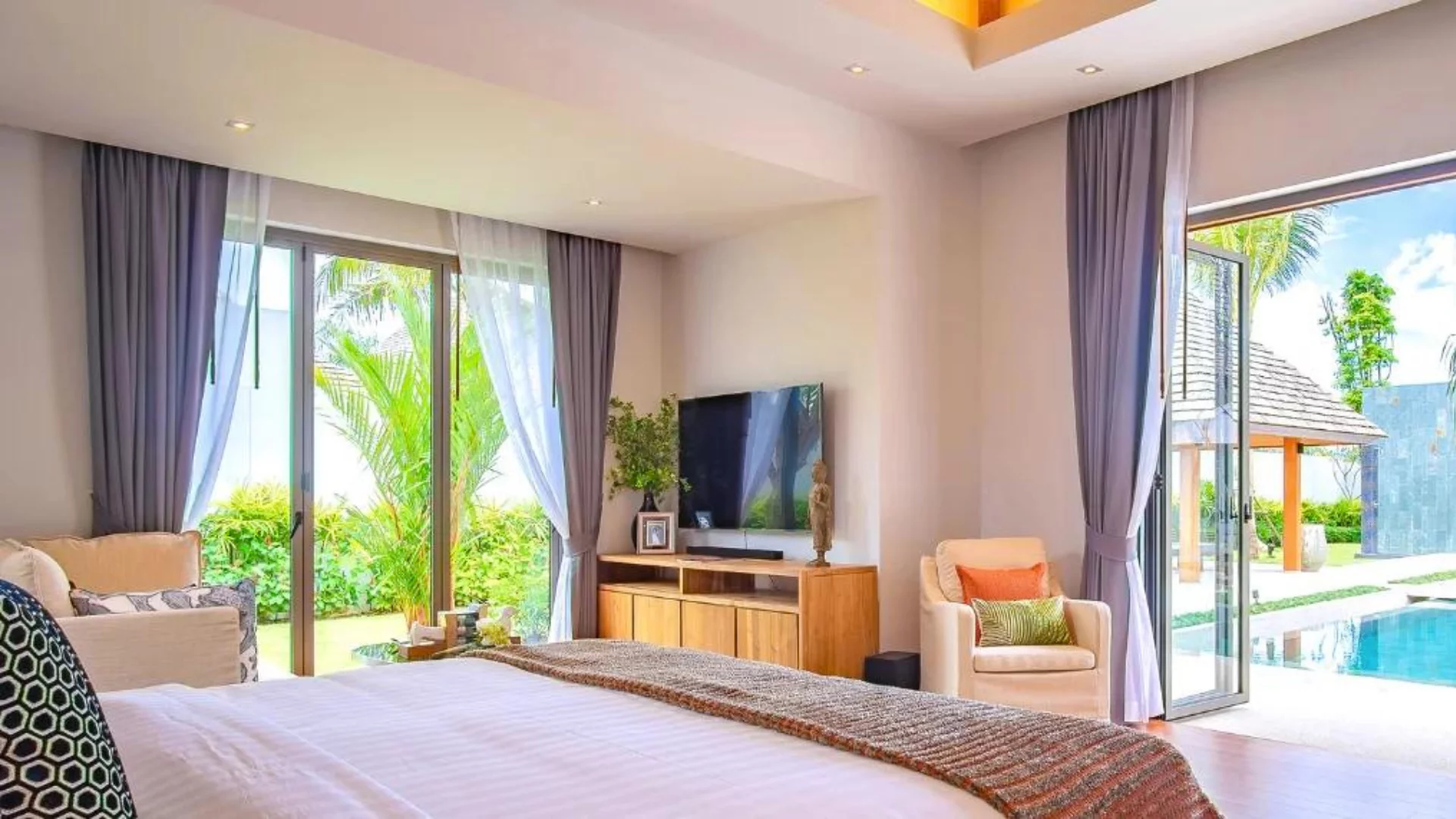 A king-size bedroom with access to the pool at a villa in Phuket