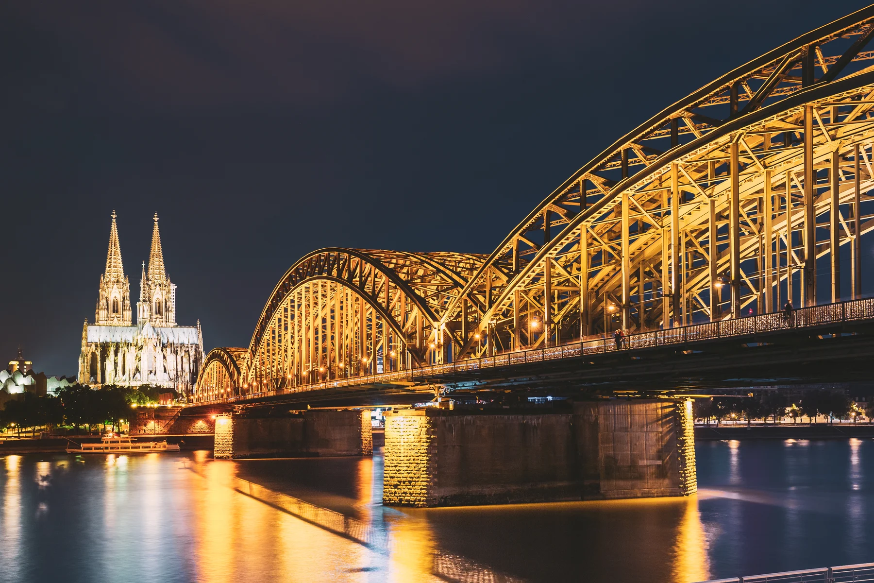 Cologne, Germany. Night view of Cologne Cathedral and Hohenzollern Bridge. Gothic cathedral at dusk