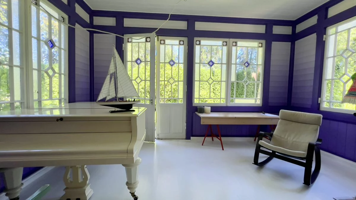 Комната в ярких, фиолетовых тонах. В комнате стоит фортепьяно.