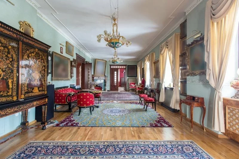 Colorful carpets and many paintings on the walls of the living room of the castle in the village of Blago