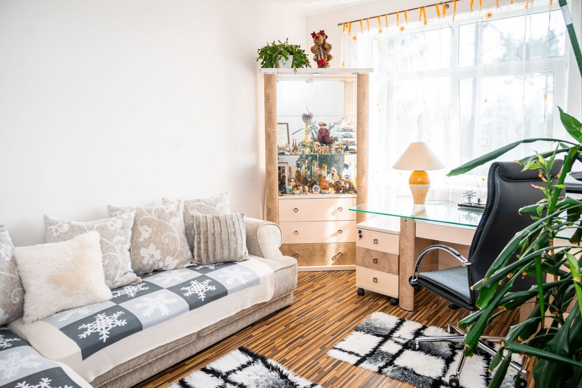 Комната в доме в Латвии, с диваном и ковриками на полу