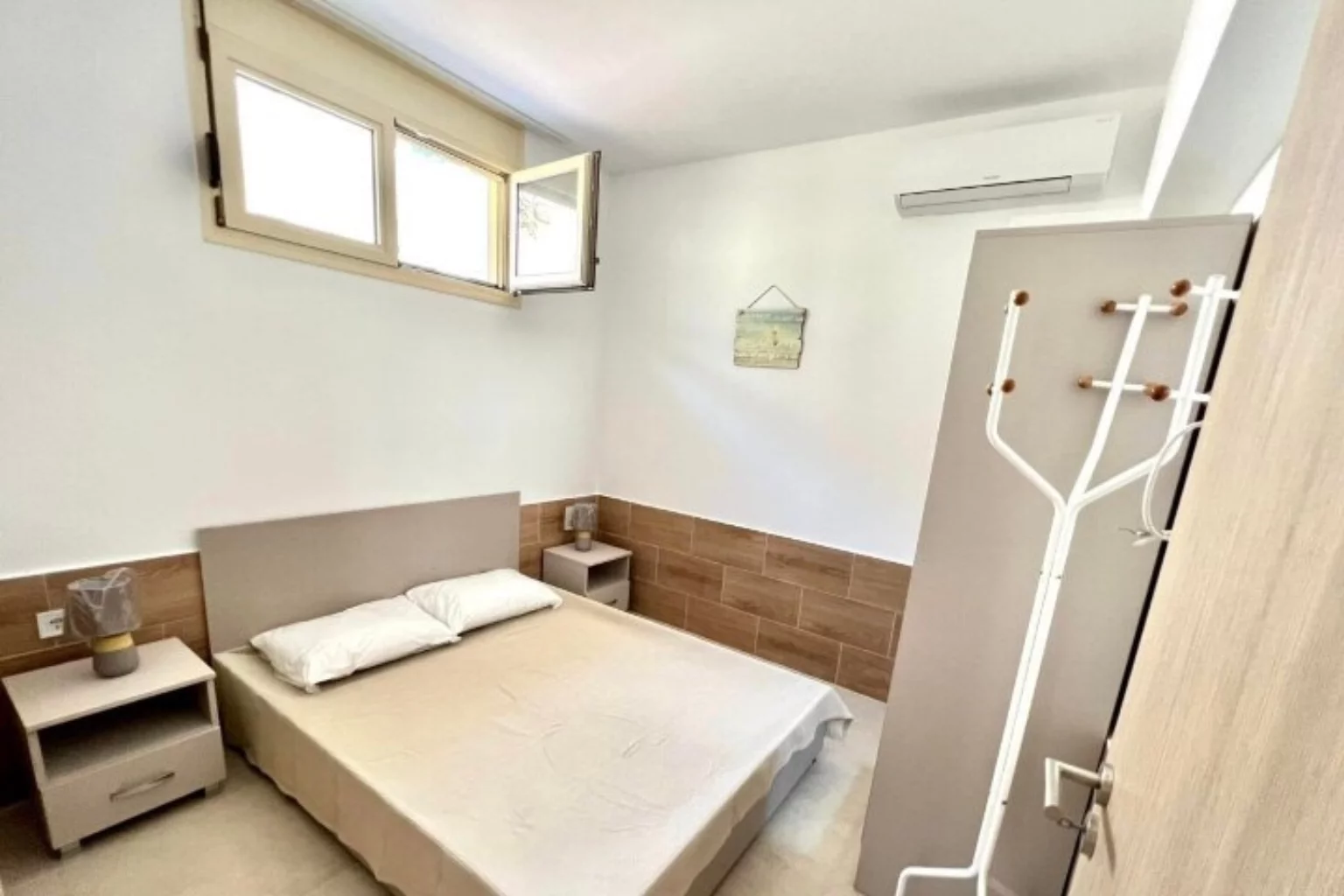 a beige bed in the bedroom of a flat in Greece
