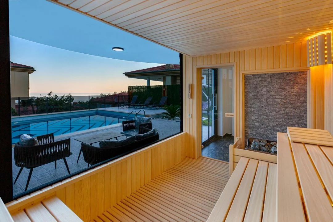 sauna with a panoramic window overlooking the pool